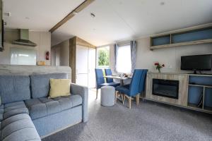 a living room with a couch and a table at Tehidy Holiday Park in Illogan