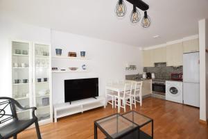 un soggiorno con televisione e una sala da pranzo di Apartamento Alfredo a O Pindo