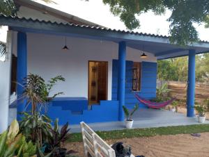 a blue house with a hammock on the porch at Lilly Pilly Villa Arugambay in Arugam Bay