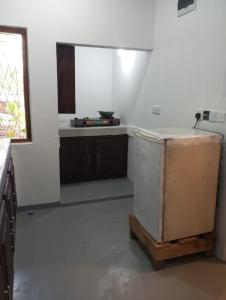 a kitchen with a refrigerator and a window at Lilly Pilly Villa Arugambay in Arugam Bay +12 photos