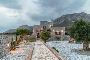 a stone house with mountains in the background at Armenopetra View Gerolimenas in Gerolimenas