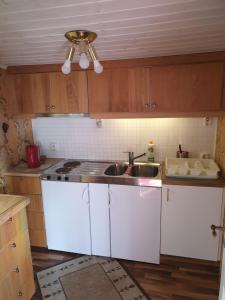 a kitchen with white cabinets and a sink at Falkenberg Olofsbo Havsbad in Falkenberg