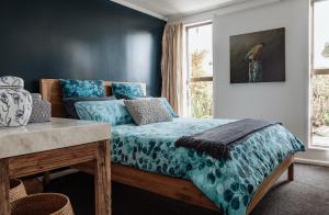una camera da letto con un letto con lenzuola blu e una finestra di TWO FOUR CRON Franz Josef a Franz Josef