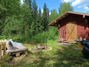 a log cabin with a couch in the yard at Le Paradis Blanc Sauna & Spa in Kortetniemi