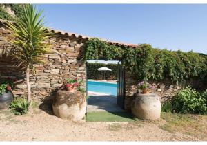 a doorway into a stone house with two large pots at SOLAR DAS ARCAS Manor House in Podence