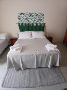 a bedroom with a large bed with a green headboard at Casa di max in Brindisi