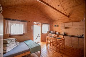 a kitchen with a bed and a table in a room at BENA pokoje i domki in Dziwnówek