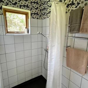 a bathroom with a shower with a shower curtain at Klefstad gård in Linghem +57 photos