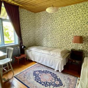 a bedroom with a bed in a room with wallpaper at Klefstad gård in Linghem