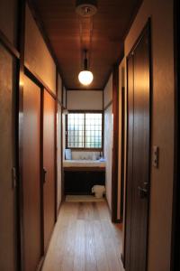 a hallway with a bathroom with a toilet and a window at Hostel Hana An in Tokyo