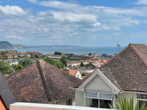 a view of a town with houses and the ocean at Little Briar in Lyme Regis