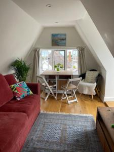 a living room with a couch and a table and chairs at Little Briar in Lyme Regis