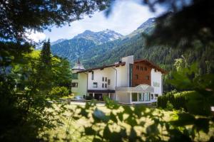 a large building with mountains in the background at Hotel Hafele in Kaunertal +18 photos