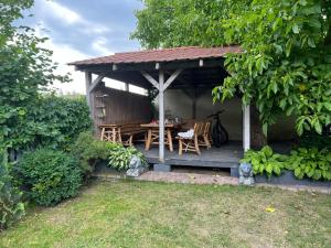 a wooden gazebo with a wooden table and chairs at Pod kasztanem in Olsztynek