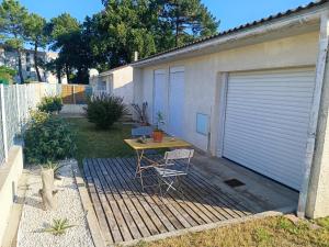 Una mesa y una silla en un patio al lado de un garaje. en Villa Ilanga, en Soulac-sur-Mer 10 fotos más