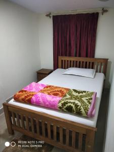 una camera da letto con un letto con una coperta colorata sopra di Munnar heritage bungalow a Munnar
