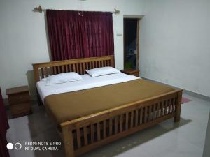 una camera da letto con un grande letto con una finestra rossa di Munnar heritage bungalow a Munnar