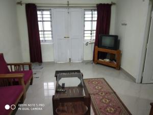 un soggiorno con un divano e una TV di Munnar heritage bungalow a Munnar