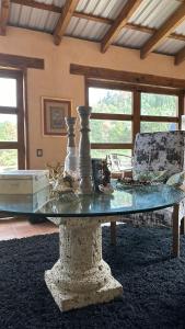 a glass table in the middle of a living room at NIDU Cabañas Boutique & Holística in Mineral del Monte