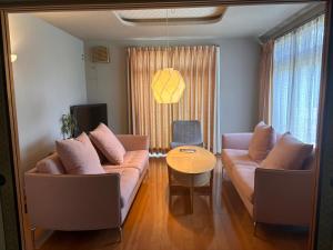 a living room with two couches and a table at Kumamoto Castle House in Kumamoto