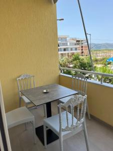 a table and chairs on a balcony with a view at Nina's Rooms in Orikum