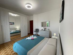 a bedroom with a large bed with a blue blanket at Water Lily Apartment in Bardello