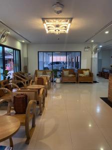 un ristorante con tavoli e sedie in una stanza di CHORLADA LANNA HOTEL a Chiang Mai