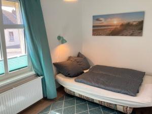 a bed sitting in a room with a window at Ferienwohnung Ahlbeck Theophil in Ahlbeck