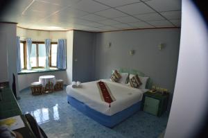 a bedroom with a bed and a table and chairs at Seabreeze Inn in Karon Beach