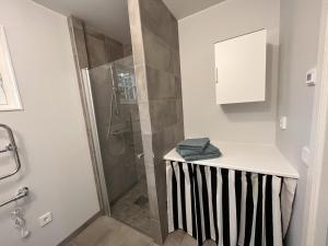 a bathroom with a shower with a black and white counter at Gläntan 