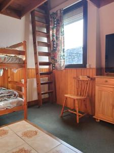 a bedroom with bunk beds and a chair and a window at Appartmt 6-8 en montagne in La Pierre Saint Martin
