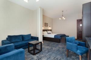a hotel room with a bed and a blue couch at Hotel Bella Casa in Tbilisi City