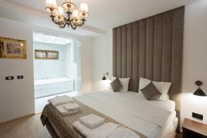 a bedroom with a large bed and a chandelier at Hotel RAS Pazarište in Novi Pazar +162 photos