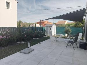 a patio with an umbrella and a table and chairs at Les lauriers roses in Fontvieille