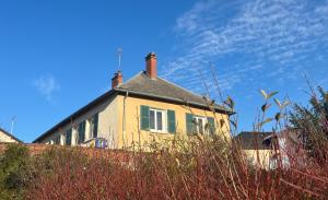 a yellow house with two chimneys on top of it at Aux Primevères in Saint-Honoré-les-Bains