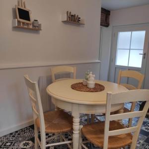 a dining room table with four chairs and a table with at Séjour champêtre et bucolique in Saint-Maurice-sur-Fessard +13 photos