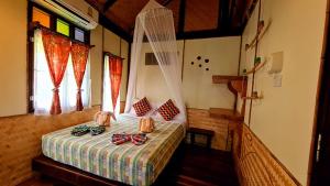 a bedroom with a bed with bow ties on it at Longtail Beach Resort in Thong Nai Pan Yai