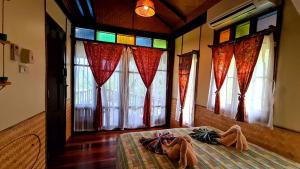 a bedroom with stained glass windows and a bed at Longtail Beach Resort in Thong Nai Pan Yai
