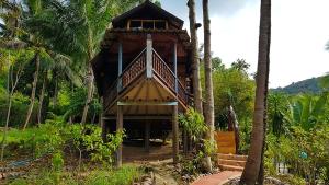 a house with a balcony in the middle of palm trees at Longtail Beach Resort in Thong Nai Pan Yai