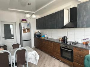 una cocina con electrodomésticos en blanco y negro y una mesa en Dzhal-29, en Bishkek