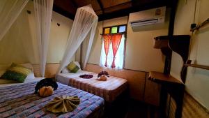 a bedroom with two beds with pumpkins on them at Longtail Beach Resort in Thong Nai Pan Yai