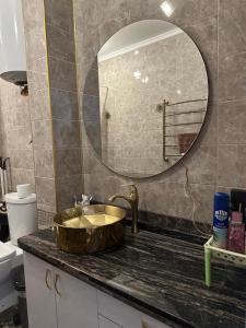 baño con lavabo de oro y espejo en Dzhal-29, en Bishkek 8 fotos más
