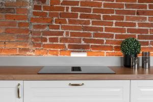 ein Laptop auf einer Theke vor einer Backsteinmauer in der Unterkunft ARCTIC HOMES - Historical Tromsø NEWLY RENOVATED in Tromsø + 21 Fotos