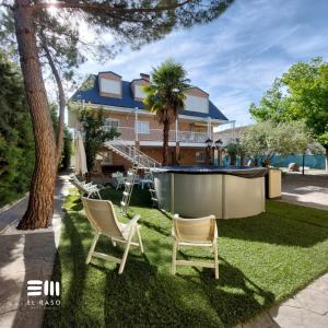 a house with two lawn chairs and a hot tub at Casa Rural El Raso in Almoguera