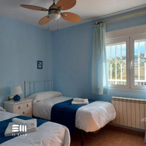 a bedroom with three beds and a ceiling fan at Casa Rural El Raso in Almoguera +53 photos