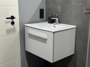 a bathroom with a white sink and a wall at Hotel Kammerkrug in Bad Harzburg +36 photos