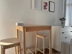 a wooden desk with two stools in a room at Comfy Room near Metro & Airport in Lisbon