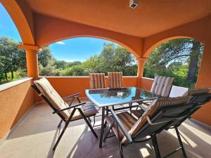 un porche grillagé avec une table et des chaises dans l'établissement Apartman Rio de Mar, à Bibinje