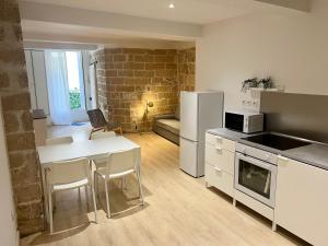 a kitchen with a table and a white refrigerator at Le poète roucher in Montpellier +10 photos