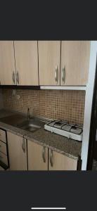 a kitchen counter with a sink and a stove at EDİRNE EYLÜL PANSİYOn in Edirne